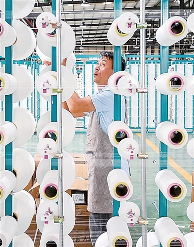 工人在毕节宏盛纺织科技有限公司纺织车间作业。李 华摄
