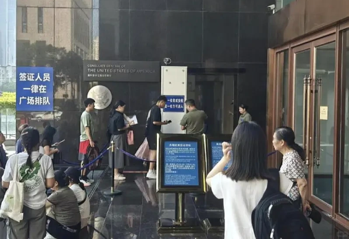 2025年7月，美国驻武汉总领事馆所在大楼门口，签证申请人排队等待。（图源：世界新闻网）