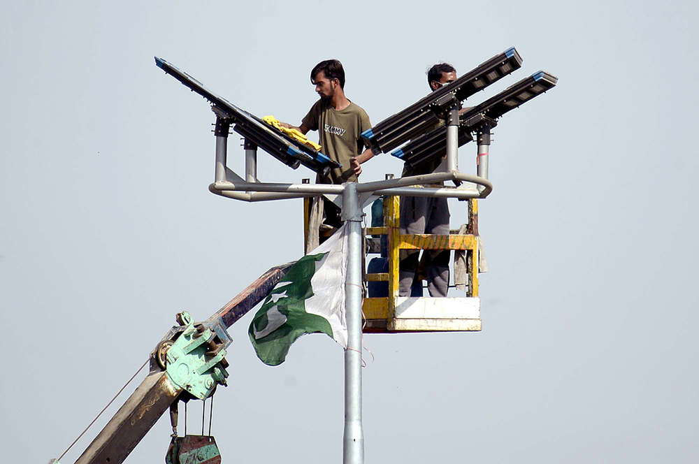 2025年12月14日,巴基斯坦卡拉奇,技术人员正在对新安装的太阳能路灯进行维护工作。视觉中国 资料图