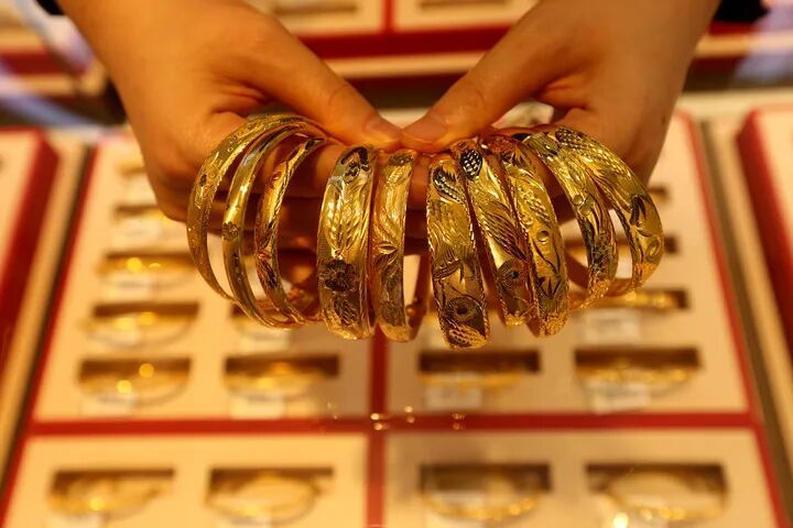 1月26日,江苏省连云港市连云区一家黄金店店员在整理黄金饰品。新华社发(王春 摄)