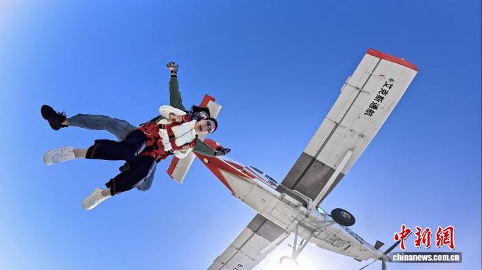 图为跳伞教练带体验者跃出舱门。蓝色气流重庆跳伞&middot;官方旗舰店 供图