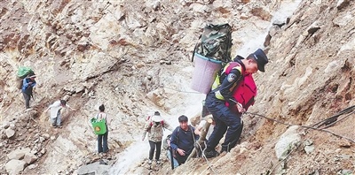 独龙江边境派出所民警和志愿者给洪灾中的被困群众送去生活物资。国家移民管理局供图