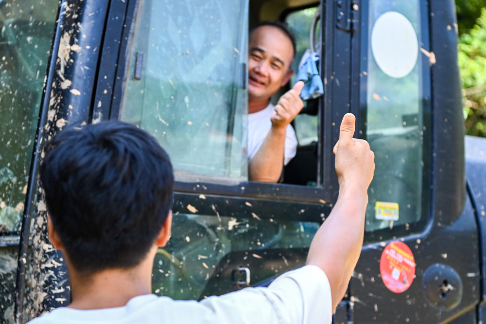 7月13日，在广西横州市，镇龙乡那旭村村民（前）给前来支援的救援人员竖起大拇指。新华社记者 曹祎铭 摄