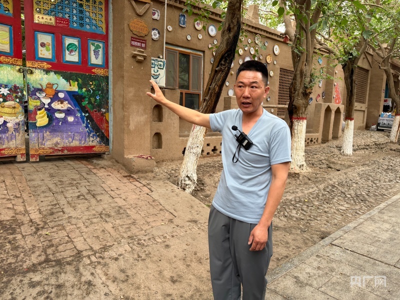 魏东正在为研学团讲解青蛙巷 （央广网记者 丁安 摄）