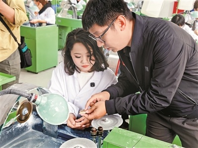沈罕（右）指导学生塑形