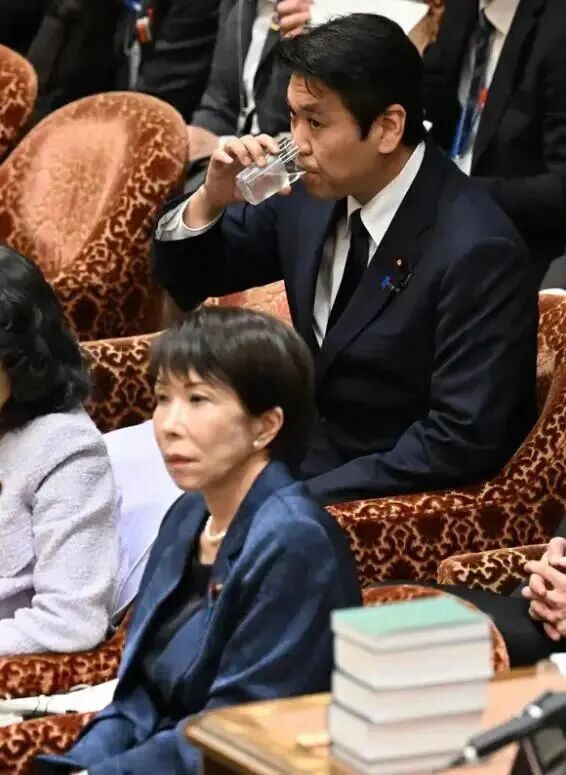 ·松本(喝水者)在众议院预算委员会的答辩现场。(日本共同社)