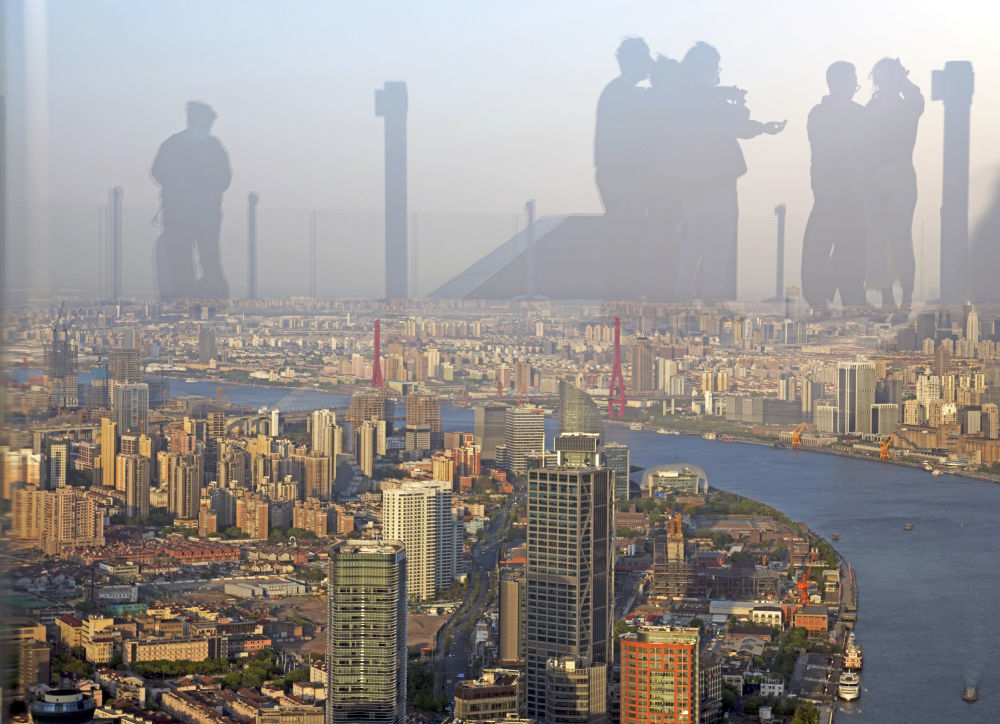 2025年4月14日,人们的身影映在上海白玉兰广场顶层的观景台玻璃上。新华社记者 刘颖 摄