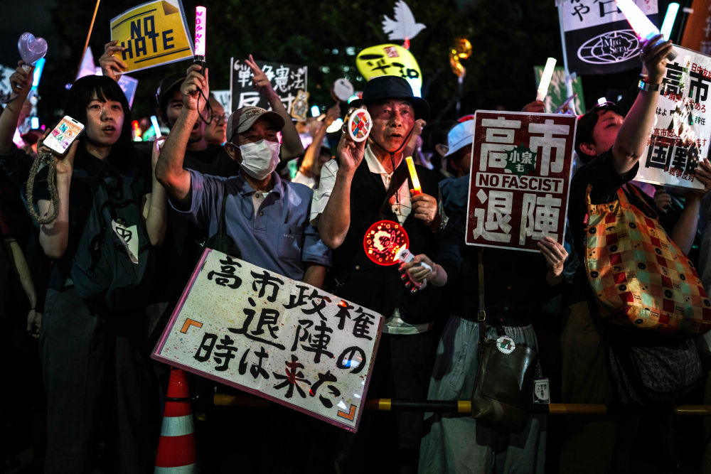 5月29日,在位于日本东京的国会议事堂前,民众手持标语参加抗议集会。新华社记者贾浩成摄