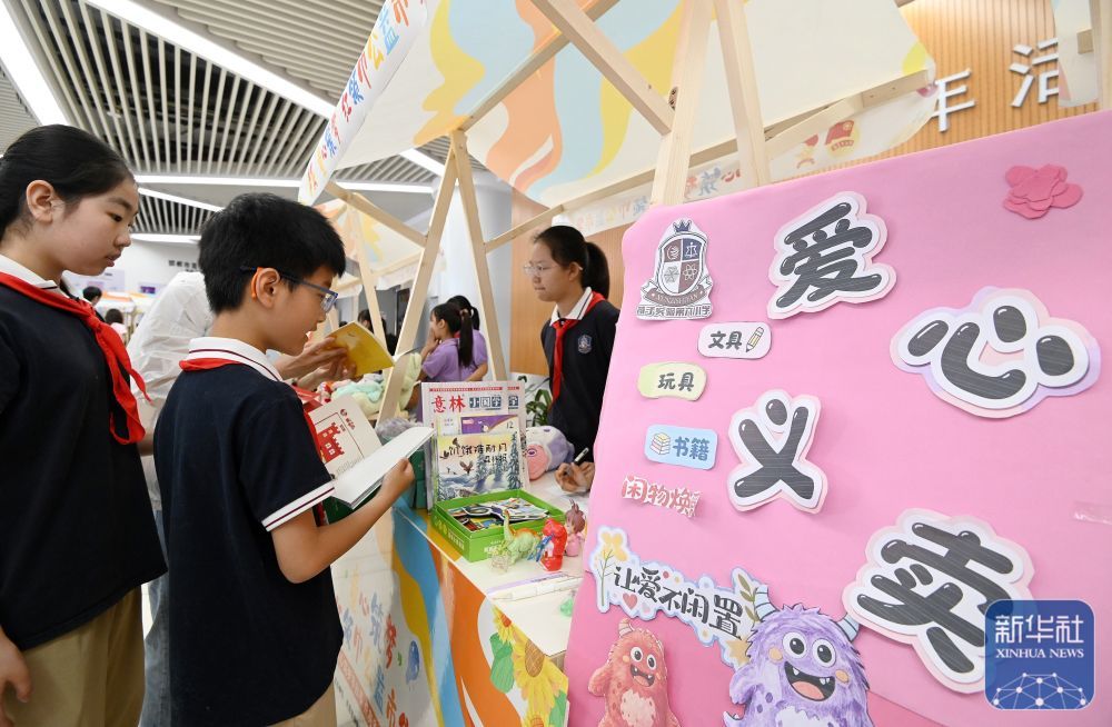 ↑ 5月30日,在河北省邯郸市“童心筑梦”红领巾公益市集活动中,少先队员们参与义卖。新华社发(郝群英摄)