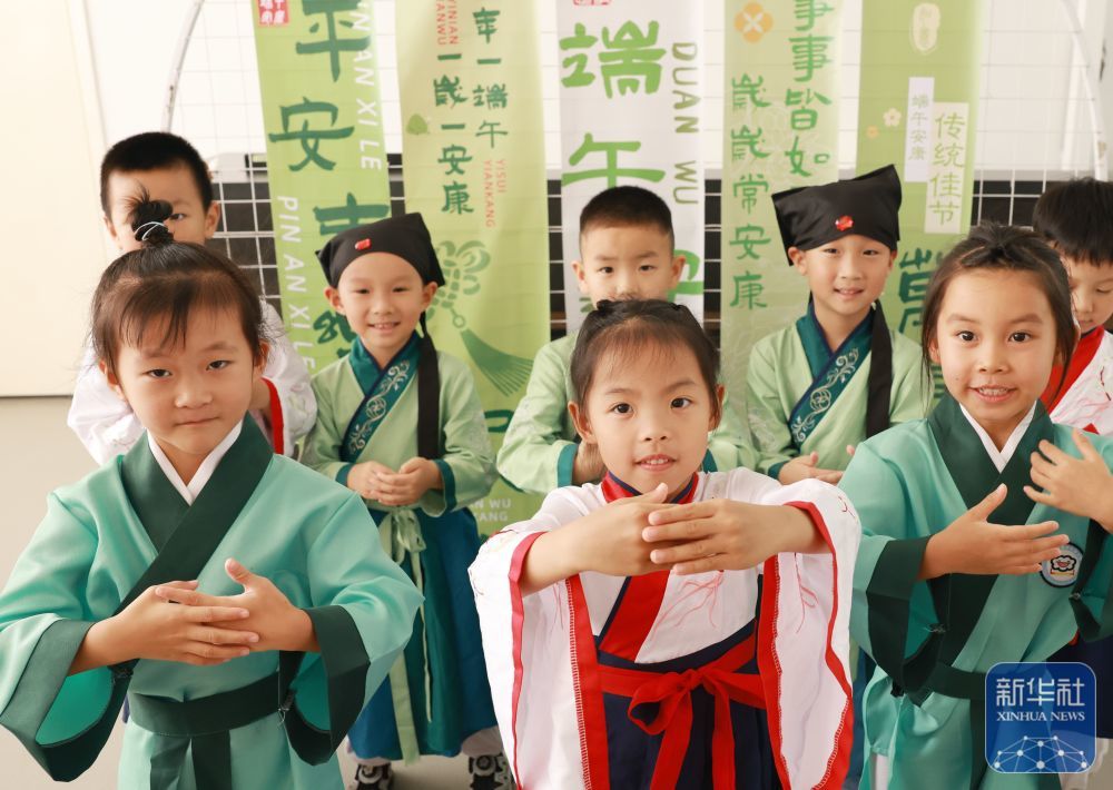 ↑ 6月17日,湖北省武汉市江岸区百步亭快乐天使幼儿园小朋友体验“稚子习礼”传统文化。新华社发(赵军摄)