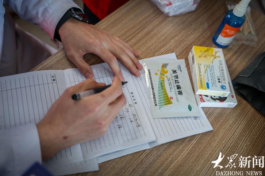 医护志愿者为老人们记好病例。