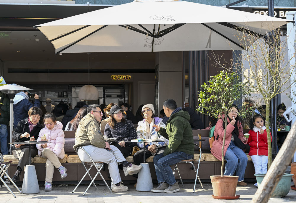 1月10日，市民游客在上海市徐汇区西岸梦中心一家商铺外享用甜品。新华社记者陈浩明 摄