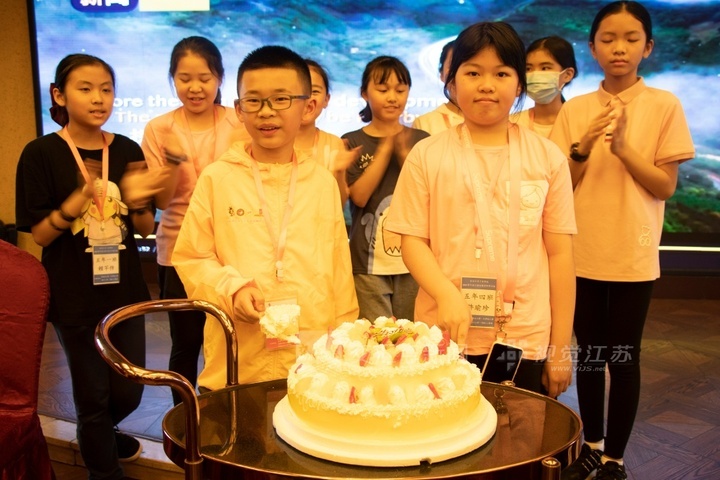 2021年“两岸青少年成渝双城研学营”在游船上举办的同龄生日晚会。(图中前排两位为分别来自重庆和台湾的小营员)