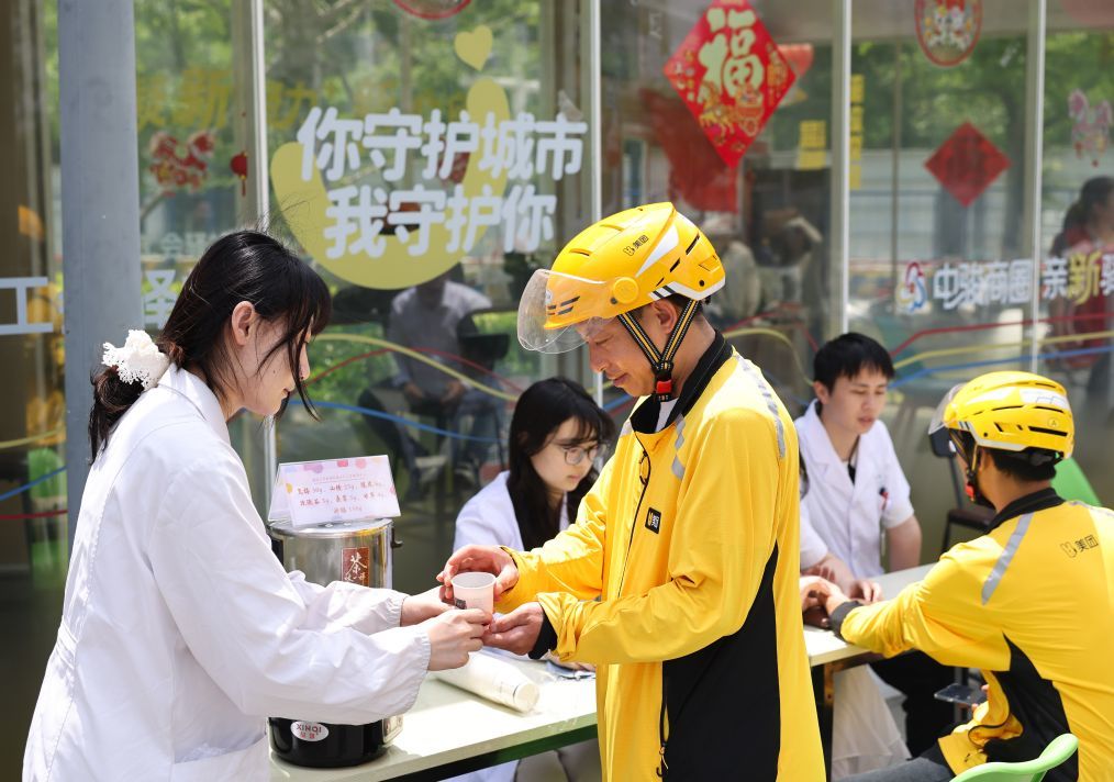 5月15日,在江苏省泰州市海陵区京泰路街道中骏商圈亲“新”驿站,医护人员为外卖员送上中医茶饮。 新华社发(顾继红 摄)