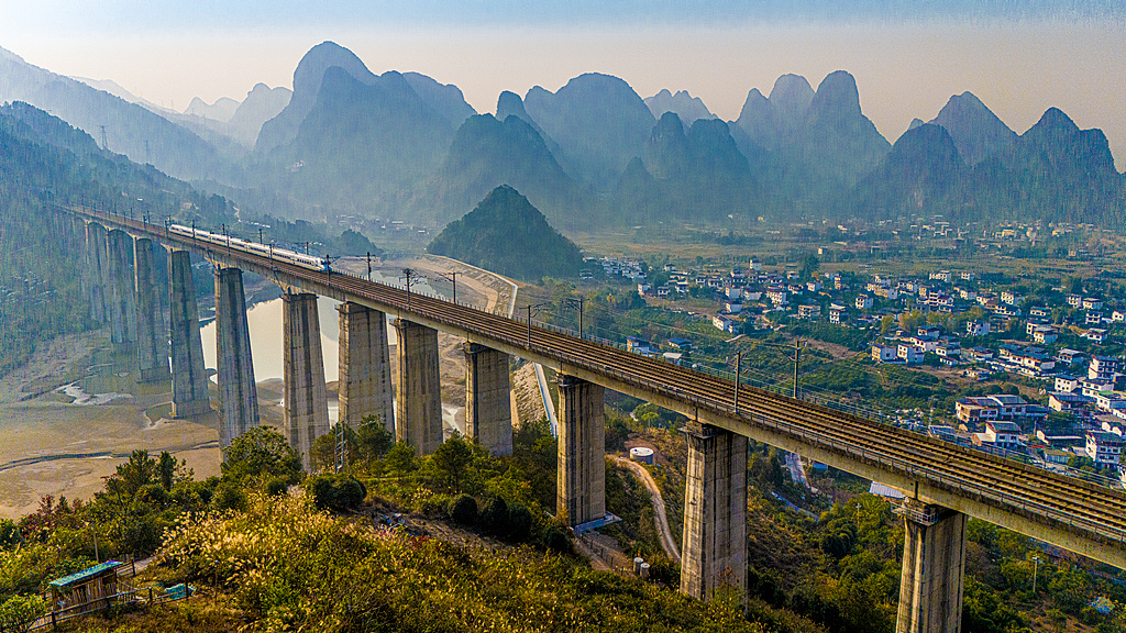 在桂林山水间，中国高铁列车疾驰而过。（视觉中国）