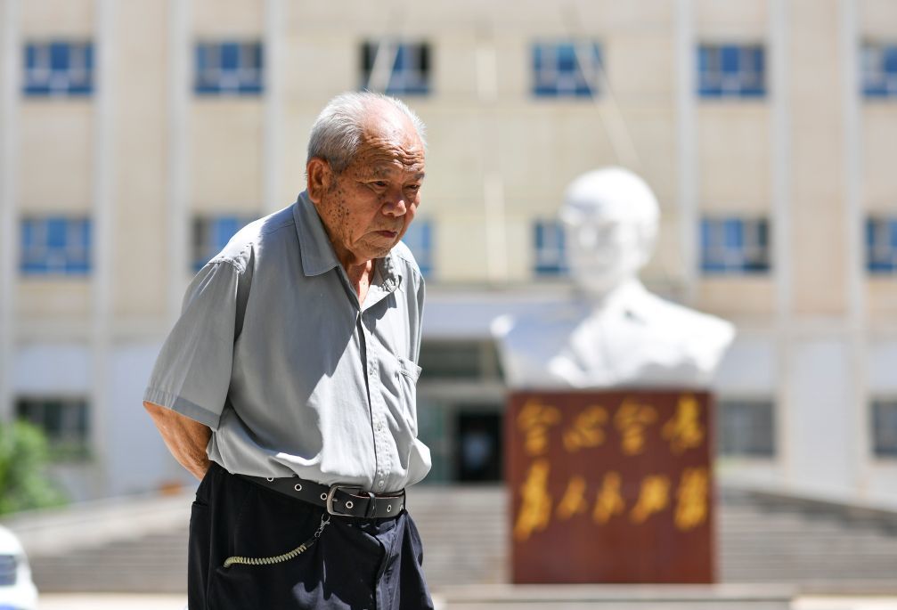 2026年7月30日，吴登云经过立在乌恰县人民医院大楼前的白求恩雕像。1999年6月，吴登云荣获“白求恩奖章”。