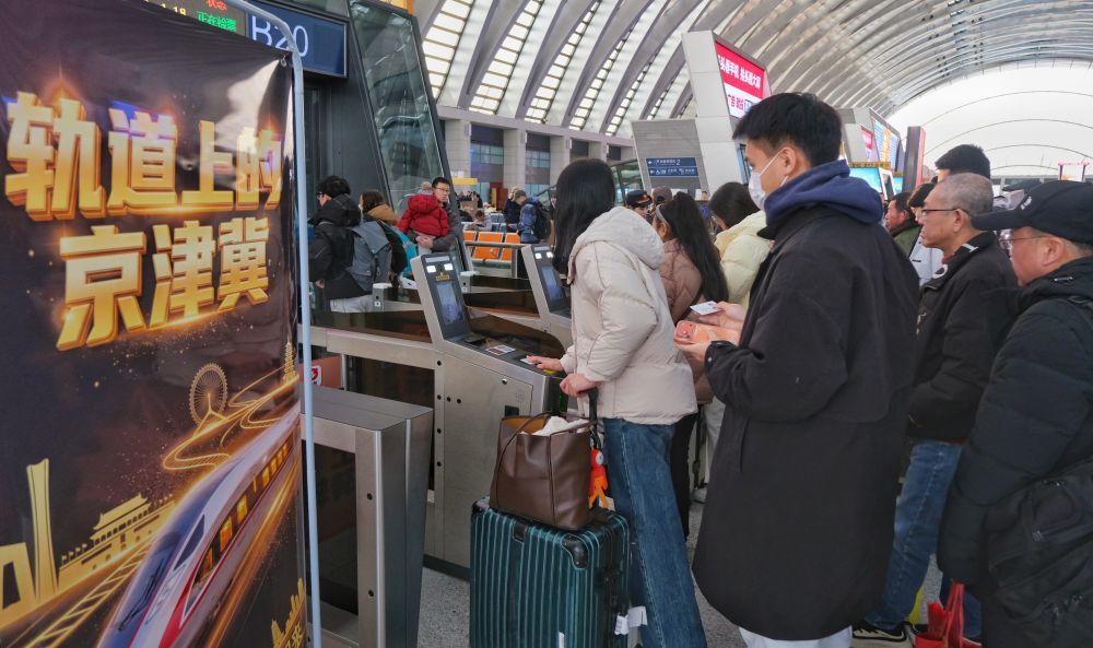 1月26日,旅客在天津西站检票准备搭乘京津冀环线高铁列车。(新华社发 杨宝森 摄)