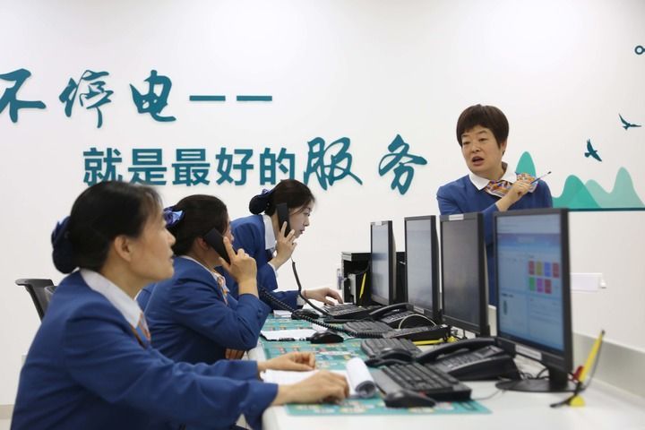 2月21日,在山东省昌乐县,国网昌乐县供电公司配网抢修指挥班班长钟文娟(右一)与同事开展工单处置和指令派发工作。新华社发(张正杰 摄)