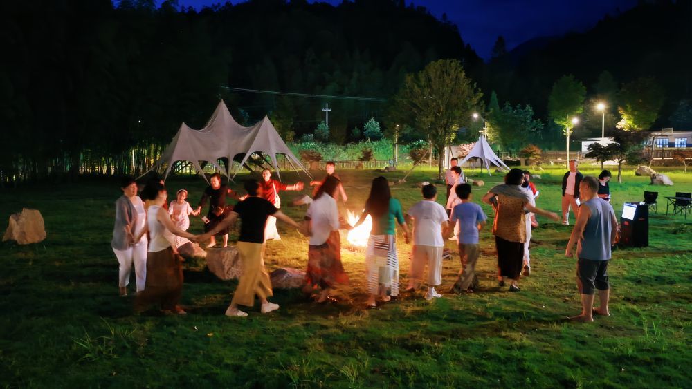 在湖南郴州桂东县民宿露营地，游客参与篝火歌舞活动。（受访者供图）