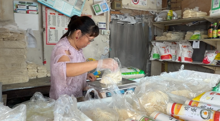 积水退后,上海金山区吕巷镇干巷菜市场,经营户杨阿姨正把米面一摞摞码齐。 “i金山”微信公众号 图