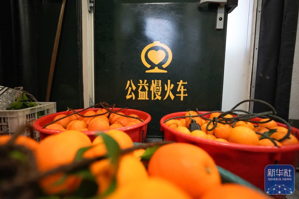 ↑ 2月12日,村民带的新鲜水果摆放在7272次公益“慢火车”车厢过道。新华社记者 刘续 摄
