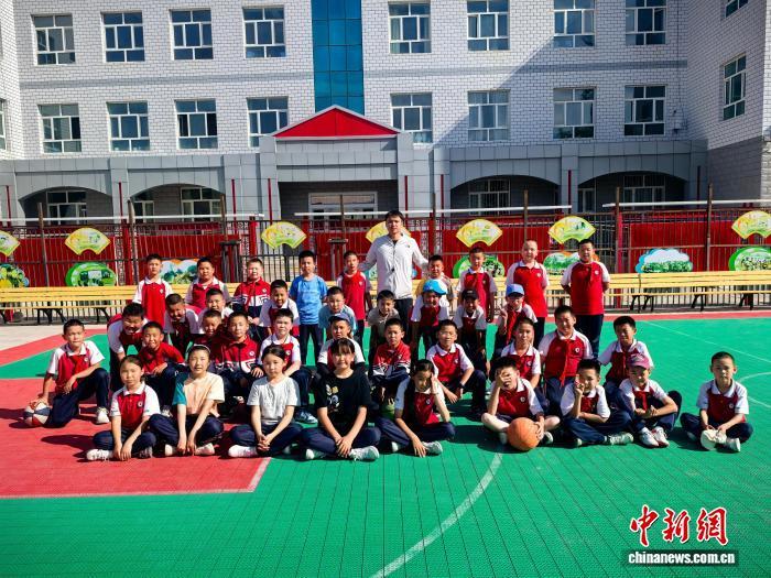 在和布克赛尔蒙古自治县第一小学，刘馨泽与学生们合影。(资料图)受访者供图