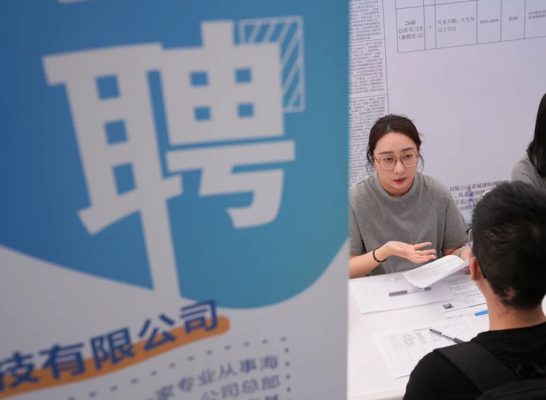 2025年5月13日,一家上市公司的招聘代表(左)在2025杭州市大学生就业·见习招聘会上与前来求职的青年学生交流 / 新华社记者韩传号 摄