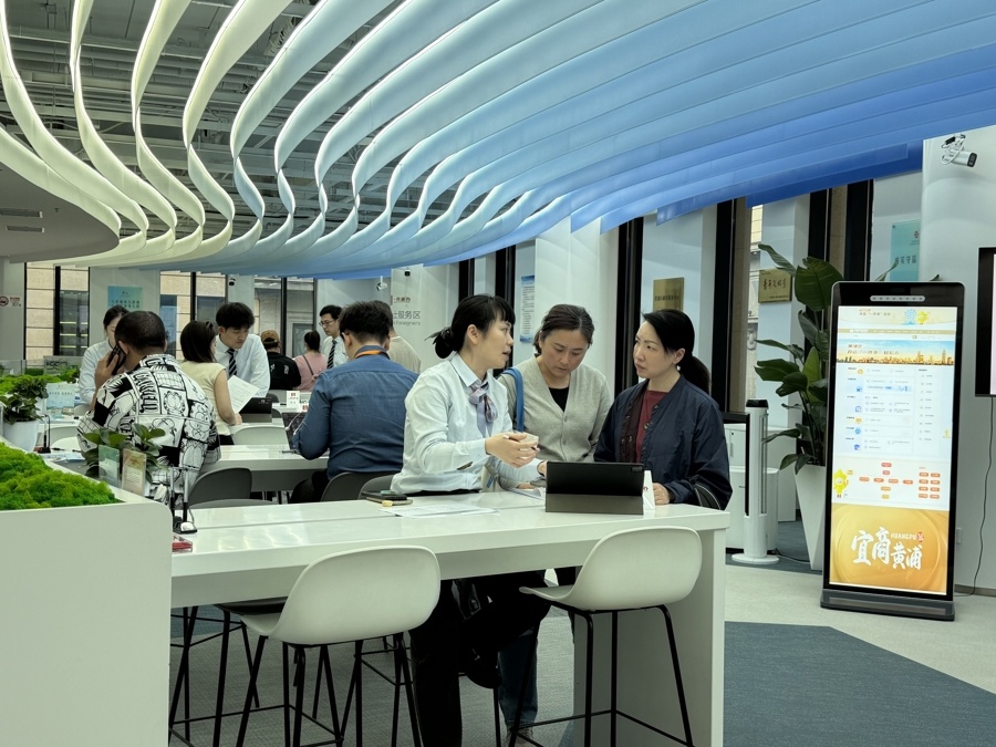 工作人员提供“肩并肩、面对面、手把手”的帮办服务,黄于悦摄