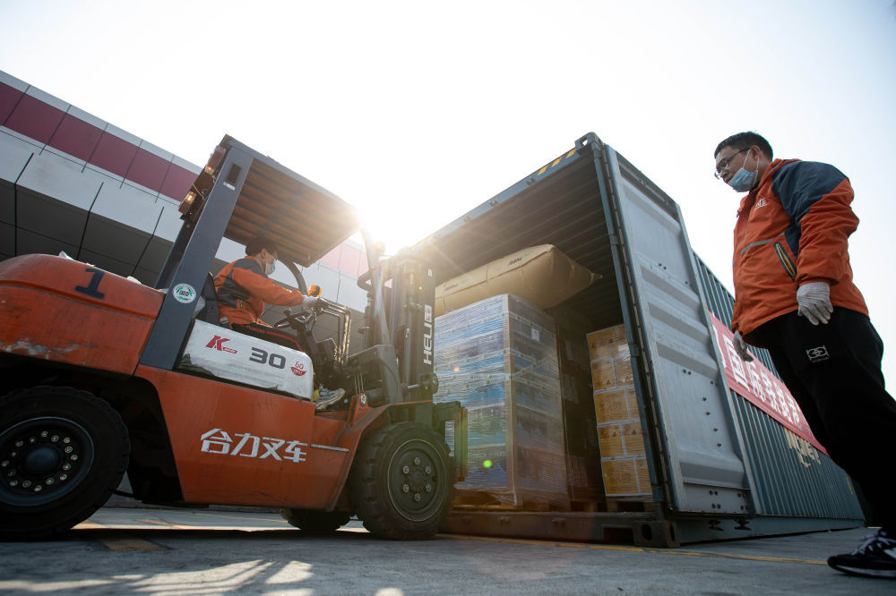 2021年2月1日，在成都国际铁路港，工作人员在搬运货物。当日，一列满载意大利红酒、饼干等食品的中欧班列抵达成都国际铁路港，为川渝两地群众带来了丰富的“洋年货”。