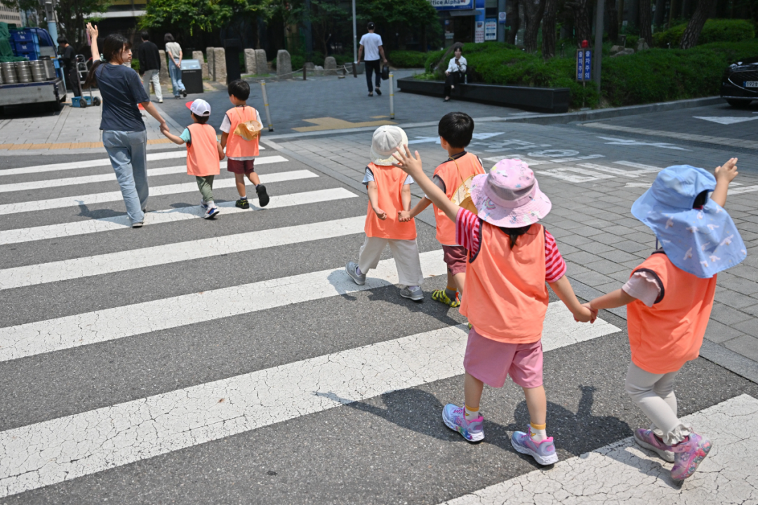 △2025年5月30日,孩子们穿过首尔的一条街道。(图源:《纽约时报》)