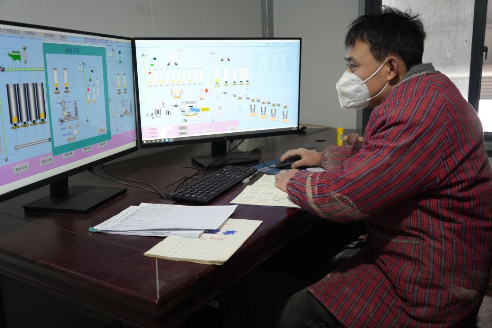 工作人员正在检查饲料自动喂养系统。新华社记者 田金文 摄