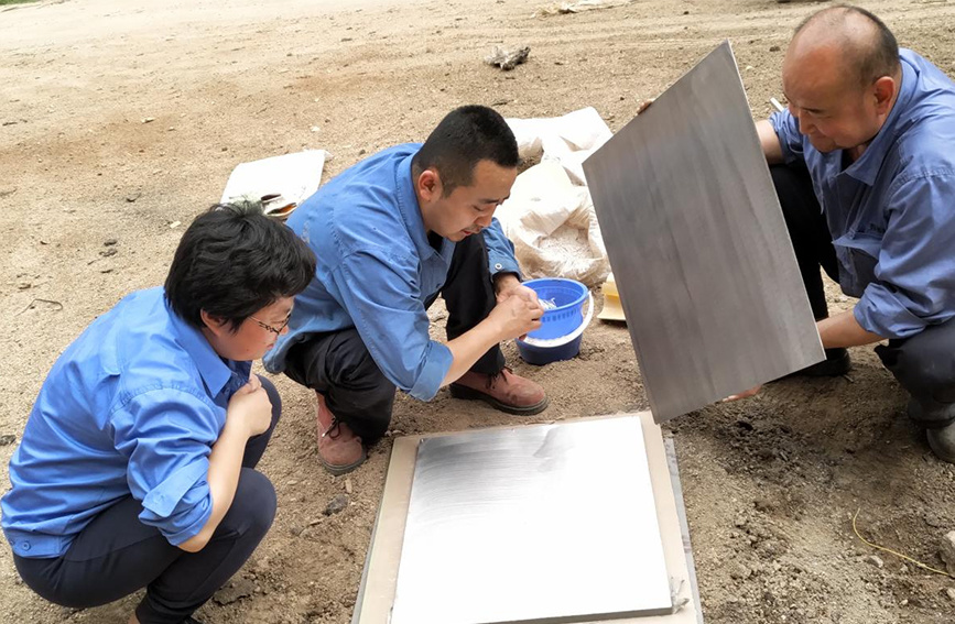 西安石油大学教授赵惠(左一)正在帮助企业开展新产品试制。受访者供图