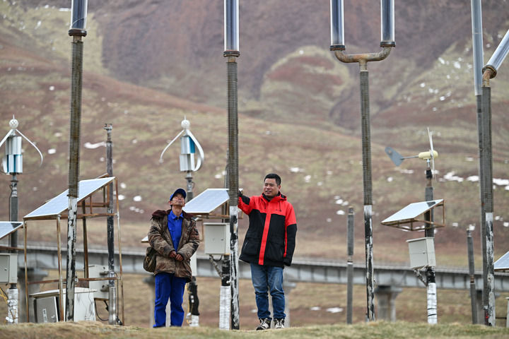 2026年6月12日,科研人员程佳(右)与王锦荣在中铁西北院风火山观测站热棒试验场内工作。新华社记者 张龙 摄
