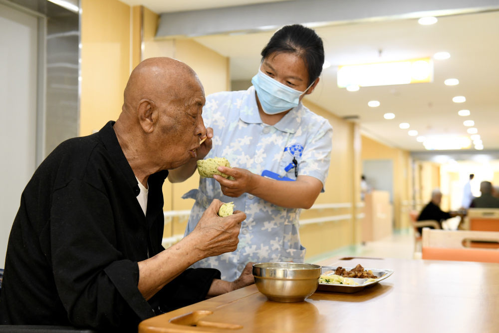 5月17日，在山东省菏泽市郓城唐塔养老公寓，工作人员在为长护险参保老人喂饭。