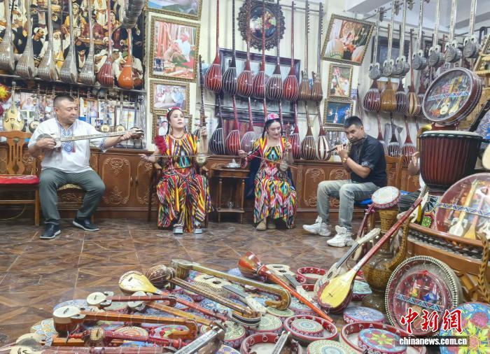 新疆喀什古城居民弹奏乐器。胡嘉琛 摄