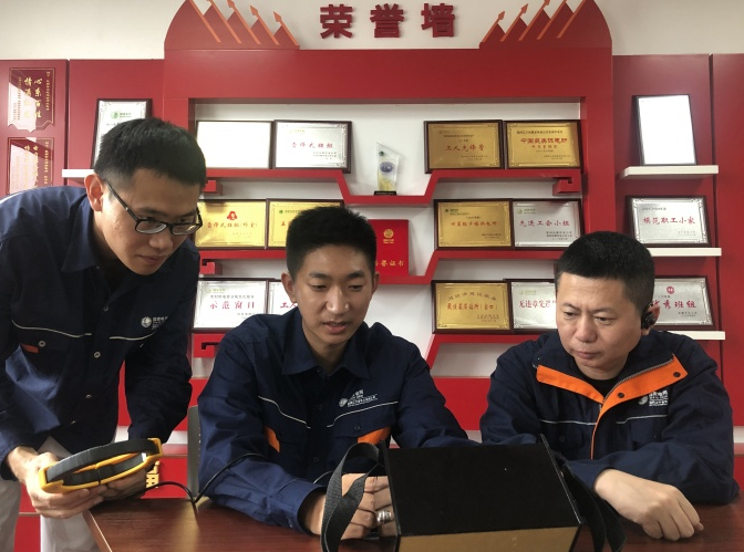 刘传波(中)与同事研讨技术创新方案。人民网记者 王斯文摄