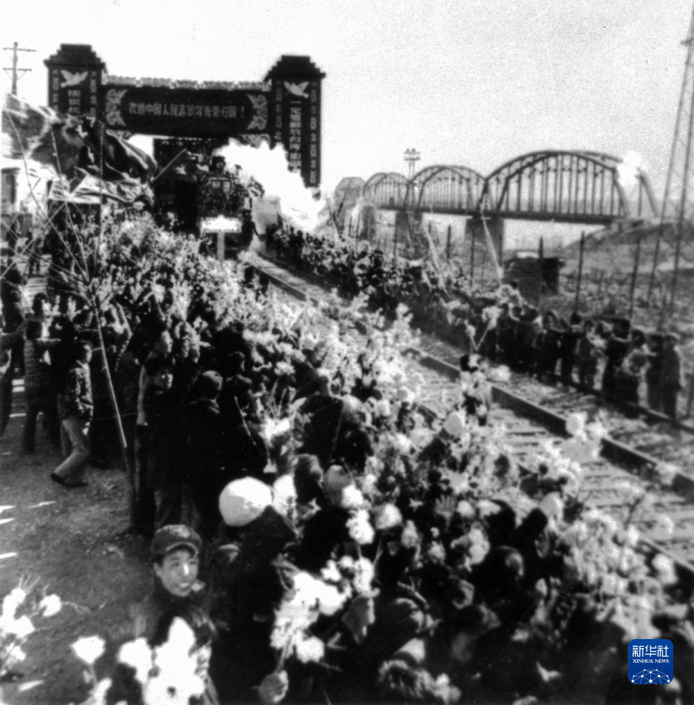 1958年10月26日，列车驶过鸭绿江畔的凯旋门，中国人民志愿军战士回到祖国怀抱。新华社发（抗美援朝纪念馆供图）