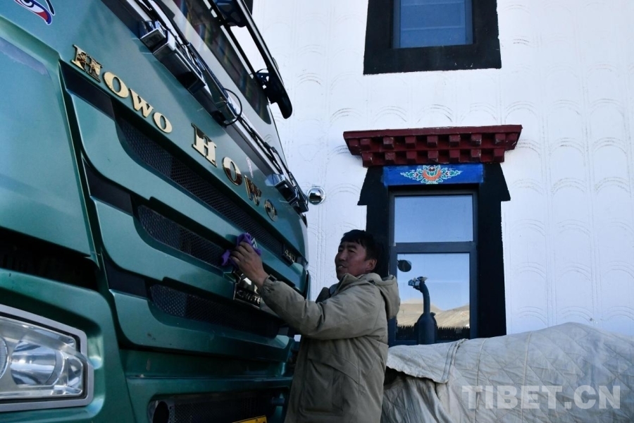 图为旦增杰布正在新家前擦拭自己的新车 摄影：赵振宇