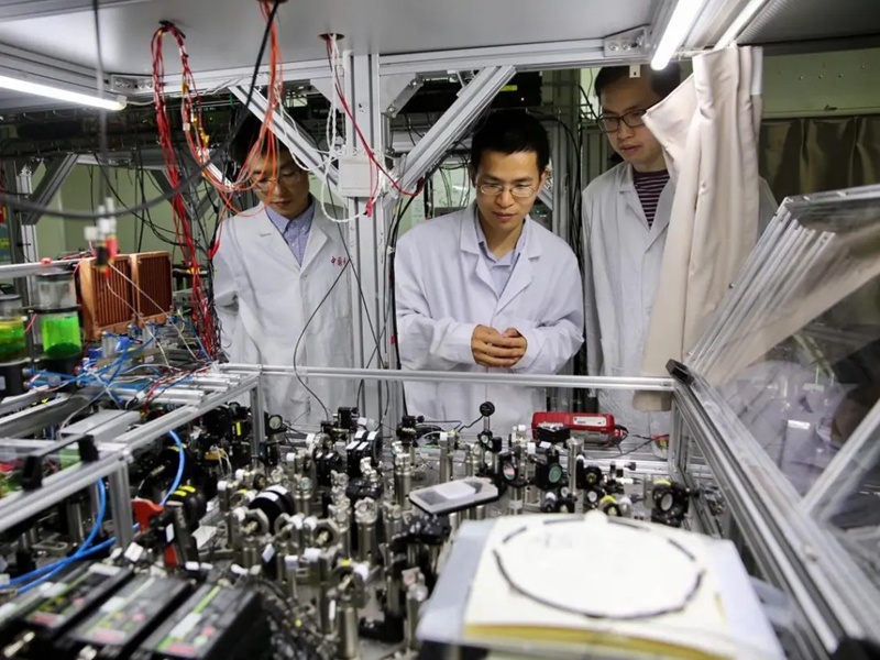 陆朝阳教授(中)和学生们在中科院量子信息和量子科技创新研究院上海实验室检查光量子计算机的运行情况(资料图片)。新华社记者 金立旺 摄