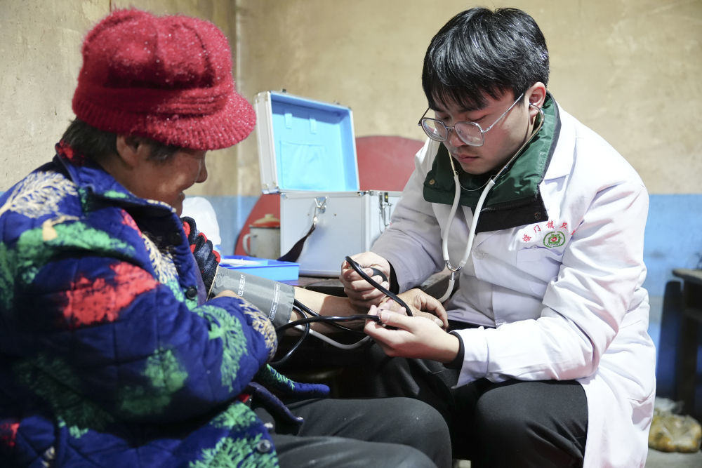 1月29日,冯莫林(右)在为青春村村民左立秀诊疗。新华社记者 邵瑞 摄