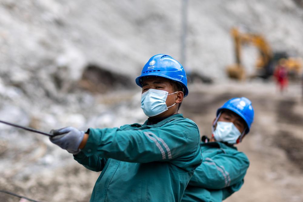 9月3日，在吉隆泥石流灾害核心区，电力工人在放导线。 新华社记者 姜帆 摄