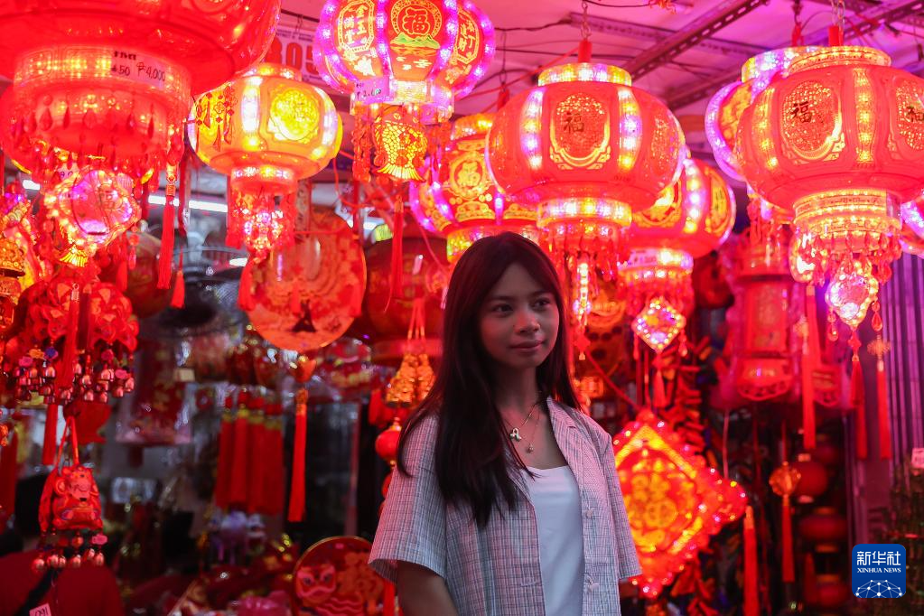 2月17日,在菲律宾马尼拉中国城,一名女子站在灯笼装饰前。 新华社发(乌马利摄)