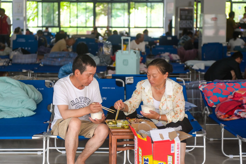 8月9日,群众在浙江温州龙湾区永兴街道罗峰实验学校避灾点吃午饭。新华社记者 江汉 摄