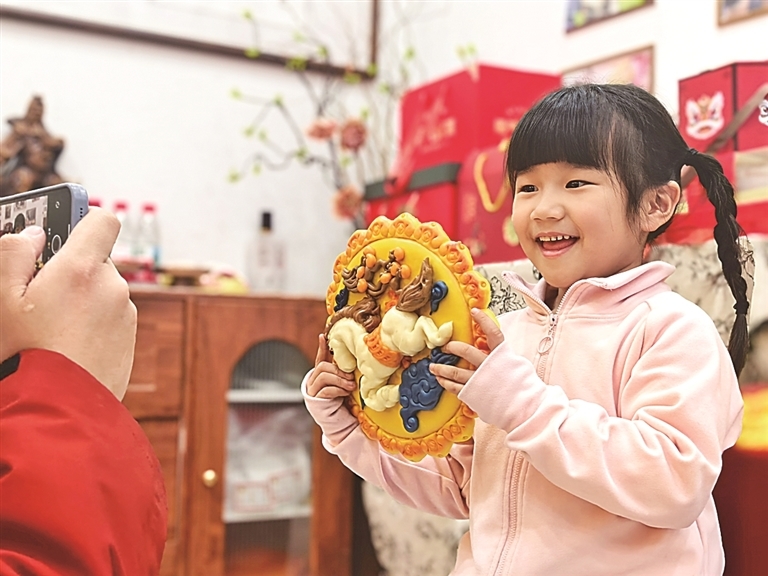 河南新乡获嘉县，小朋友在展示马年主题花馍。光明图片