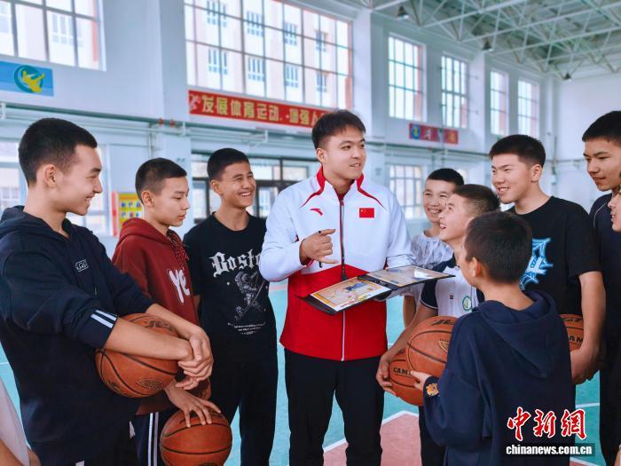 在玛纳斯县第四中学，刘馨泽为篮球队队员讲解战术。(资料图)受访者供图