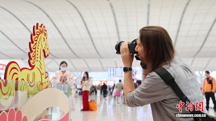 在深圳北站，来自美国的纪录片导演Craig正举着相机拍摄春运场景。卓悦 摄
