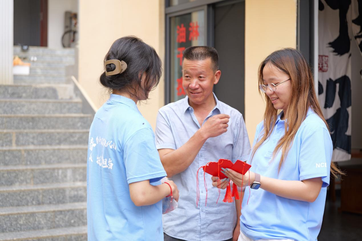 云南省寻甸回族彝族自治县柯渡镇丹桂村村民杨斌修向华北电力大学“红心E行·薪续长征”实践团成员介绍当地发展故事。刘雨涵供图