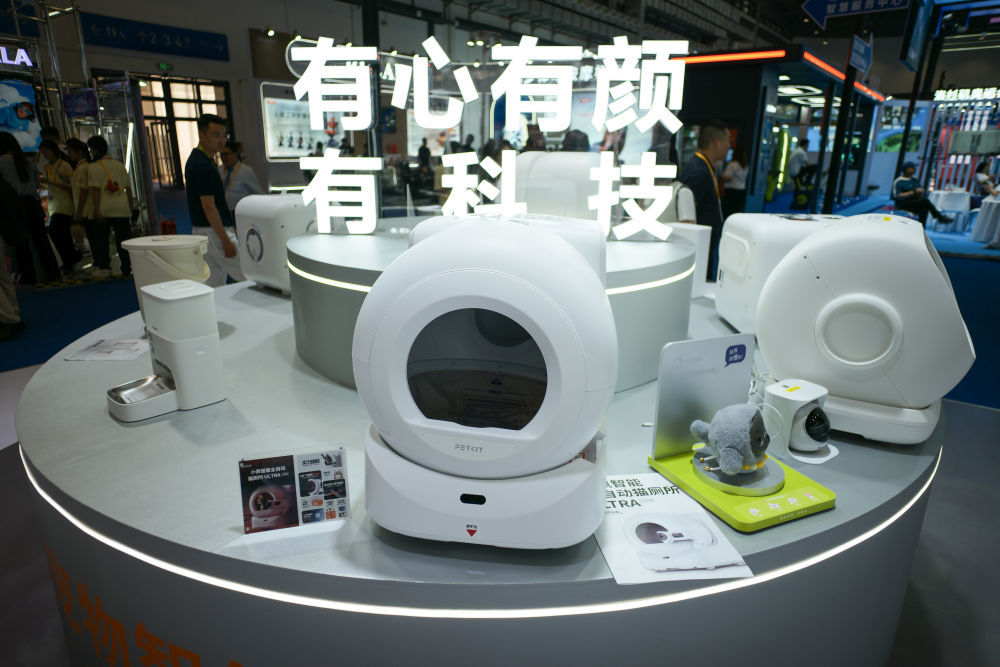 ↑ 4月14日在第六届消博会科技消费展区拍摄的智能自动猫厕所、AI宠物机器人等宠物智能用品。新华社记者 辛悦卫 摄