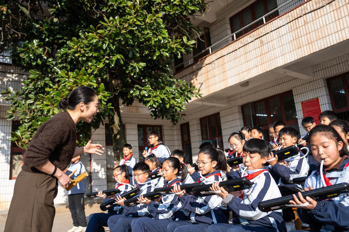 2026年1月13日,在湖南益阳南县三仙湖镇中心小学,音乐老师(左一)指导学生练习口风琴。新华社记者 陈思汗 摄