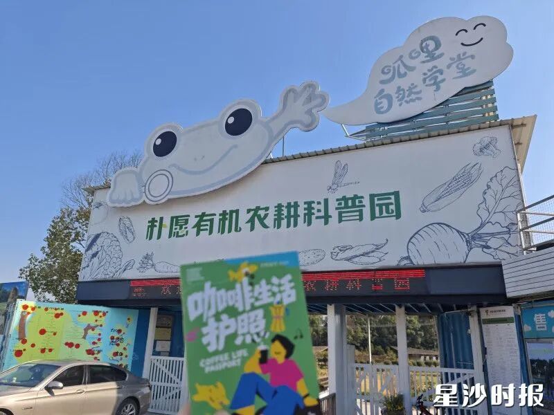游客手持护照在黄花镇朴愿有机农耕科普园打卡。